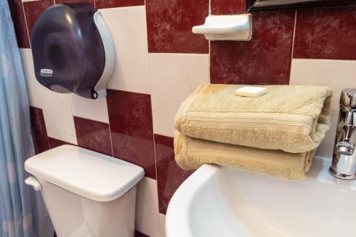 a bathroom with a toilet and a toilet paper dispenser at Casa Palma Hotel in Playa del Carmen