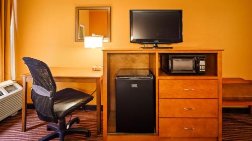 a room with a desk and a television and a chair at Best Western Executive Hotel New Haven-West Haven in West Haven