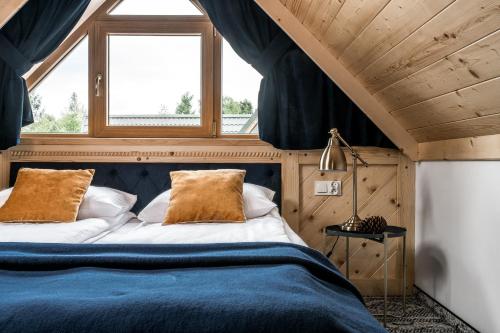 a bedroom with a bed with blue sheets and a window at Willa pod Orłem - Zakopane in Zakopane