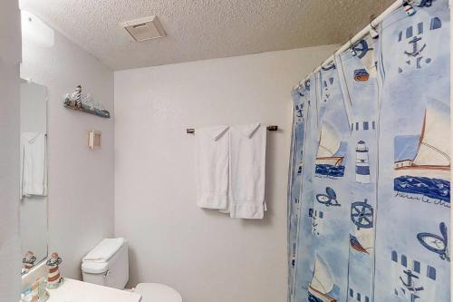 a bathroom with a toilet and a shower curtain at Ventura Condominiums #204 in South Padre Island