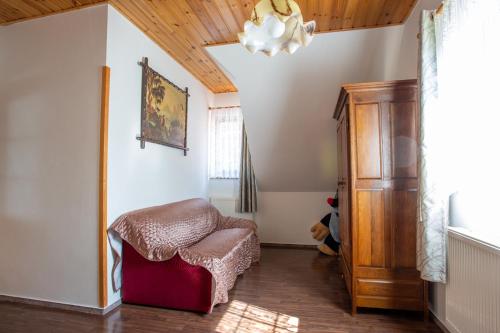 a living room with a chair and a chandelier at Hájovna Hněvnice in Hněvnice