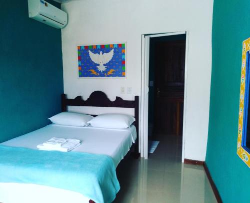 1 dormitorio con 2 camas y pared azul en SunriseBelaVista Pousada e Flats, en Paraty