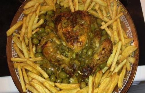 a plate of food with peas and french fries at Genova surf house in Imsouane