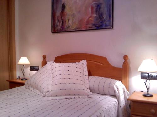 a bedroom with a white bed with two lamps at CA MARTÍN 2 in Benifallet