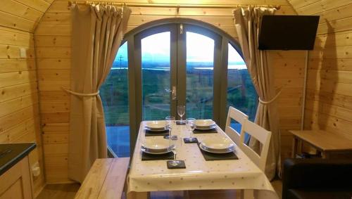 a dining room with a table and a large window at Hebrides Bothy in Swordale