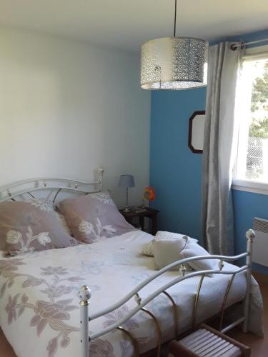 a bedroom with a bed with blue walls and a window at La Maison d'Alruna in Beauchalot