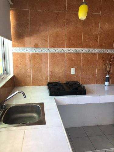 a kitchen with a sink and a stove at HOTEL LAS FUENTES in Tepotzotlán