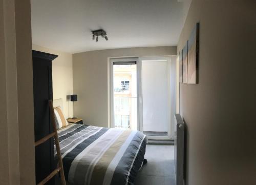 um quarto com uma cama e uma grande janela em Livorno with private parking em Nieuwpoort