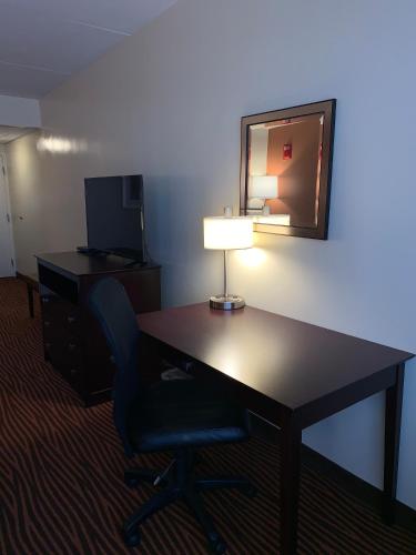 a desk with a lamp and a chair in a hotel room at Best Western Executive Hotel New Haven-West Haven in West Haven