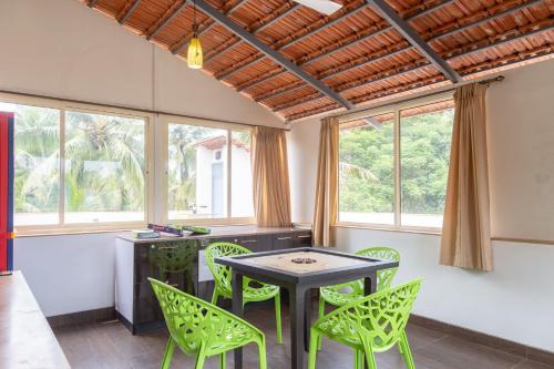 a dining room with green chairs and a table at Casa Arvana Near Calangute Beach in Calangute