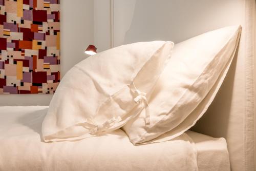 a white pillow sitting on top of a bed at Collalto24 in Treviso