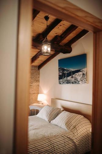 a bedroom with a bed and a ceiling at Casa Ferreira in Sabugueiro