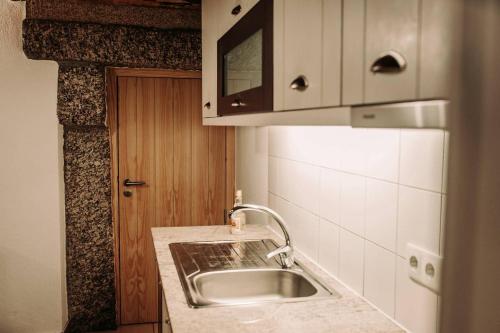 a kitchen with a sink and a counter top at Casa Ferreira in Sabugueiro