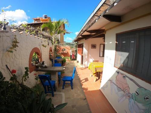 a patio of a house with blue chairs and a table at Andoriña Hostal - Bed & Breakfast in Samaipata