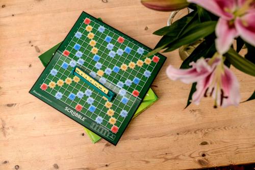 a chess board on a wooden table with flowers at Mansefield House in Arrochar