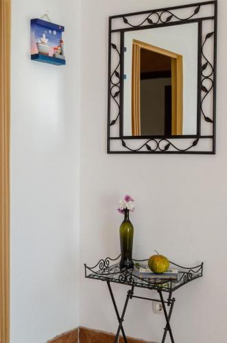 a mirror on a wall with a table with a vase on it at By the Sea Apartment Diana in Prizba