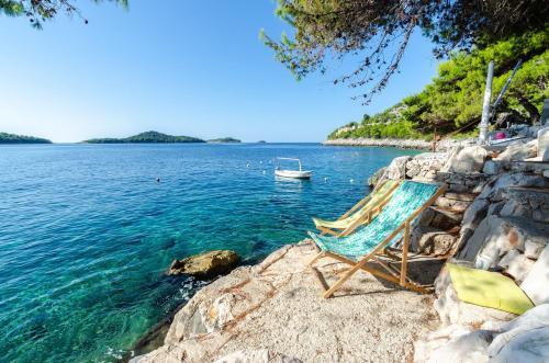 a chair sitting on the shore of a body of water at By the Sea Apartment Diana in Prizba