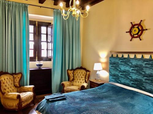 a bedroom with a blue bed and two chairs at Hotel Rural Vilaflor Self check in 24h in Vilaflor