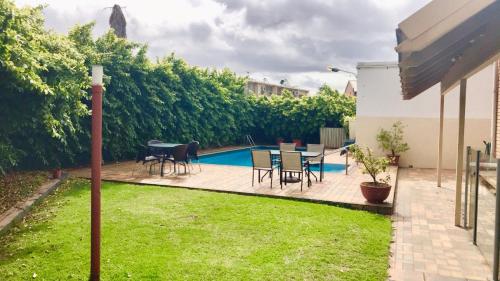 a backyard with a table and chairs and a pool at Haven Marina Motel in Adelaide