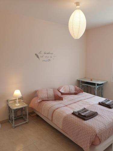 - une chambre avec un grand lit et une couverture rose dans l'établissement LE CLOS VARNAY, à Meusnes