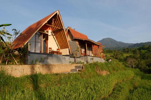 a house sitting on top of a grassy hill at Padi Bali Jatiluwih in Tabanan