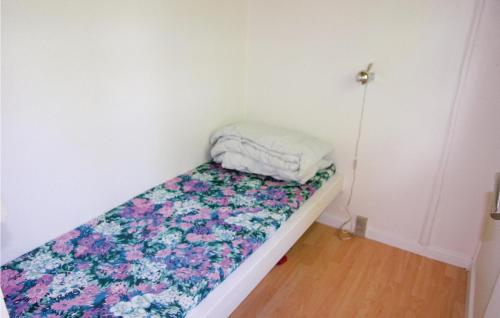HalsにあるAmazing Home In Hals With 3 Bedroomsの花柄のキルトが付いたベッドが備わる小さな客室です。