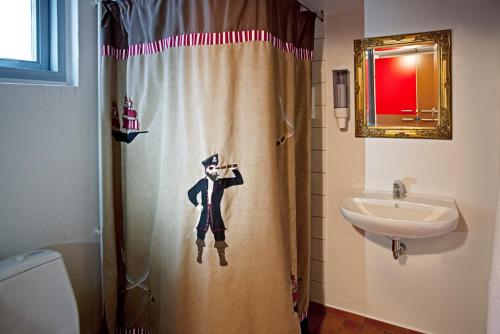 un baño con cortina de ducha con un perro. en LEGOLAND Pirates´ Inn Motel, en Billund