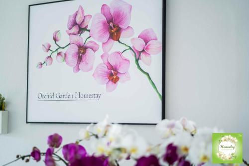 a picture of pink orchid flowers in front of a picture at Can Tho Orchid Garden Homestay in Can Tho