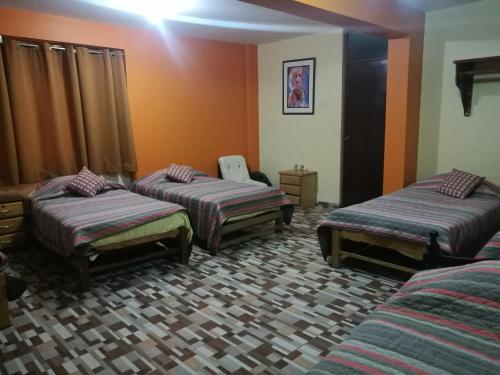 a room with three beds and a chair in it at Matryoshka in Ica