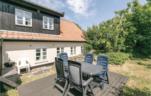 a patio with a table and chairs on a deck at Skagenhuset Lejl 1 in Allinge