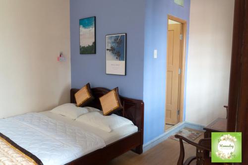 a bedroom with a bed with a blue wall at Can Tho Orchid Garden Homestay in Can Tho