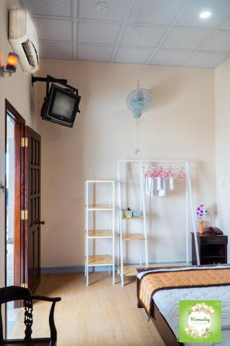 a bedroom with a bed and a tv on a wall at Can Tho Orchid Garden Homestay in Can Tho