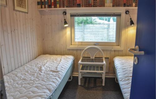ニュボーにあるPet Friendly Home In Nyborg With House Sea Viewのベッド2台、椅子、窓が備わる客室です。