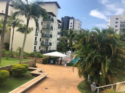a view of a courtyard with palm trees and a building at Apartamento lazer na rua da praia in Riviera de São Lourenço