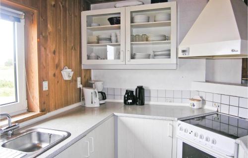 a kitchen with white cabinets and a sink at Holiday Home Norges Fjelde Fanø V in Fanø