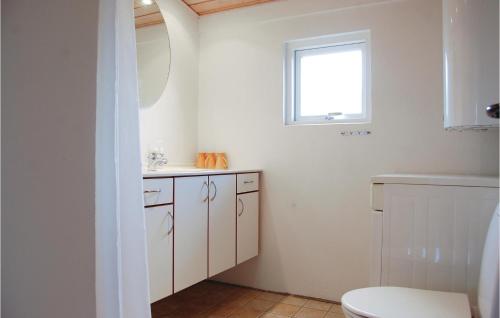 ハザスレウにあるNice Home In Haderslev With House Sea Viewのバスルーム(トイレ、洗面台付)、窓が備わります。