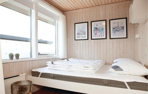 1 cama en una habitación con 3 cuadros en la pared en 2 Bedroom Beautiful Home In Pandrup, en Rødhus