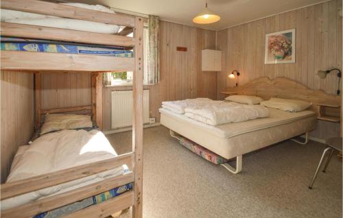 two bunk beds in a room with wooden walls at 3 Bedroom Amazing Home In Fars in Hvalpsund