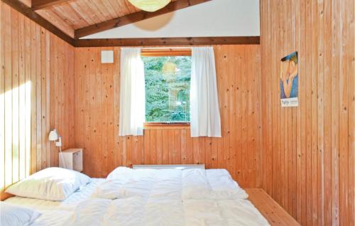 ReersøにあるBeautiful Home In Store Fuglede With 2 Bedrooms And Wifiの木製の壁に大きなベッドが備わるベッドルーム1室