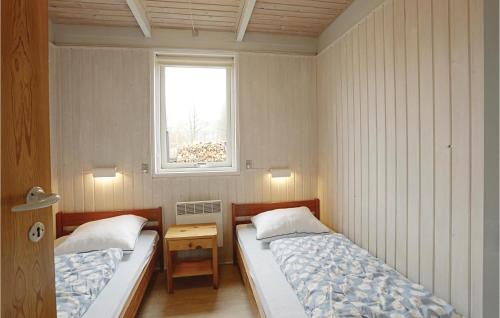 Fagus في Arnager: سريرين في غرفة صغيرة مع نافذة