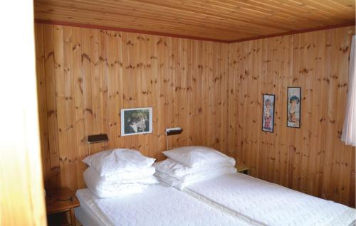 una camera da letto con pareti in legno e un letto con cuscini bianchi di Nice Home In lbk With 2 Bedrooms ad Ålbæk