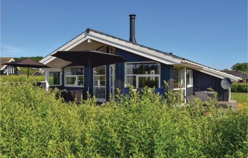 una casa azul con un paraguas en el césped en Stunning Home In Rudkbing With Sauna, en Spodsbjerg