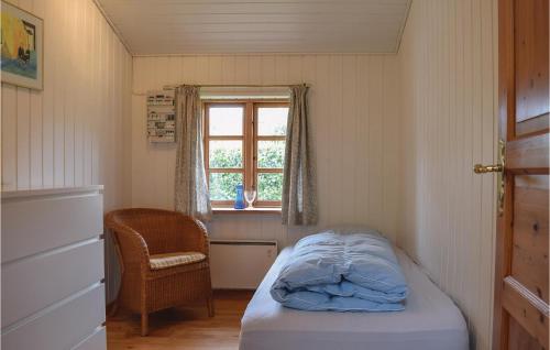 ヒュールスミンネにあるAwesome Home In Juelsminde With 3 Bedrooms And Wifiのベッドと窓が備わる小さな客室です。