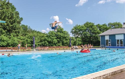 a man jumping into a swimming pool at Nice Apartment In Lgumkloster With Wifi And Outdoor Swimming Pool in Løgumkloster