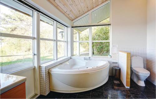 a large bathroom with a tub and a toilet at Holiday Home Lersøvej in Rønne