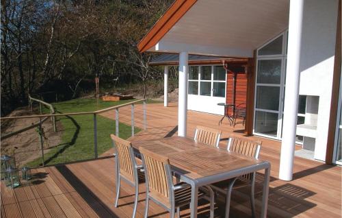 a wooden deck with a table and chairs on a house at Holiday Home Lersøvej in Rønne