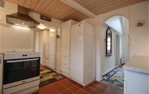 a kitchen with white cabinets and a stove at Three-Bedroom Holiday Home In Hojer in Højer