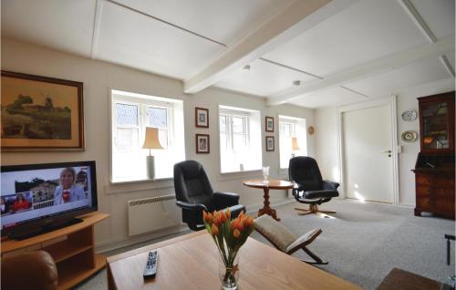 a living room with a tv and chairs and a table at Three-Bedroom Holiday Home In Hojer in Højer