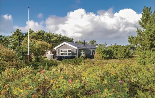 a house on top of a hill with a field at Three-Bedroom Holiday Home In Henne in Henne Strand