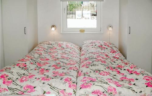 a bed with a floral bedspread in a room with a window at Awesome Home In Hejls With Kitchen in Hejls